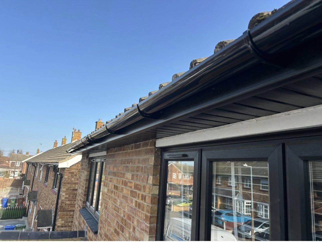Crisp new roofline with black fascia and guttering above bifold doors