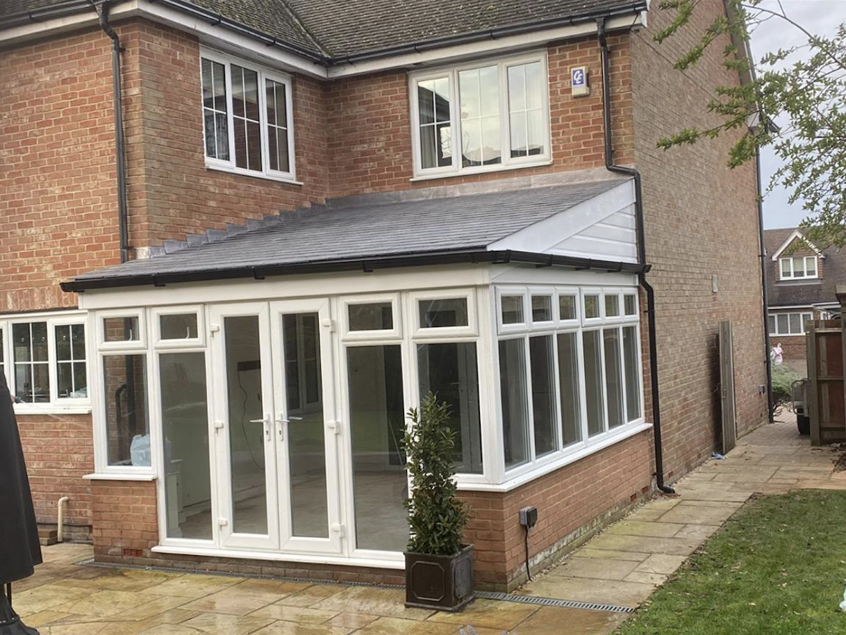 Lean-to conservatory with slate roof against a brick home