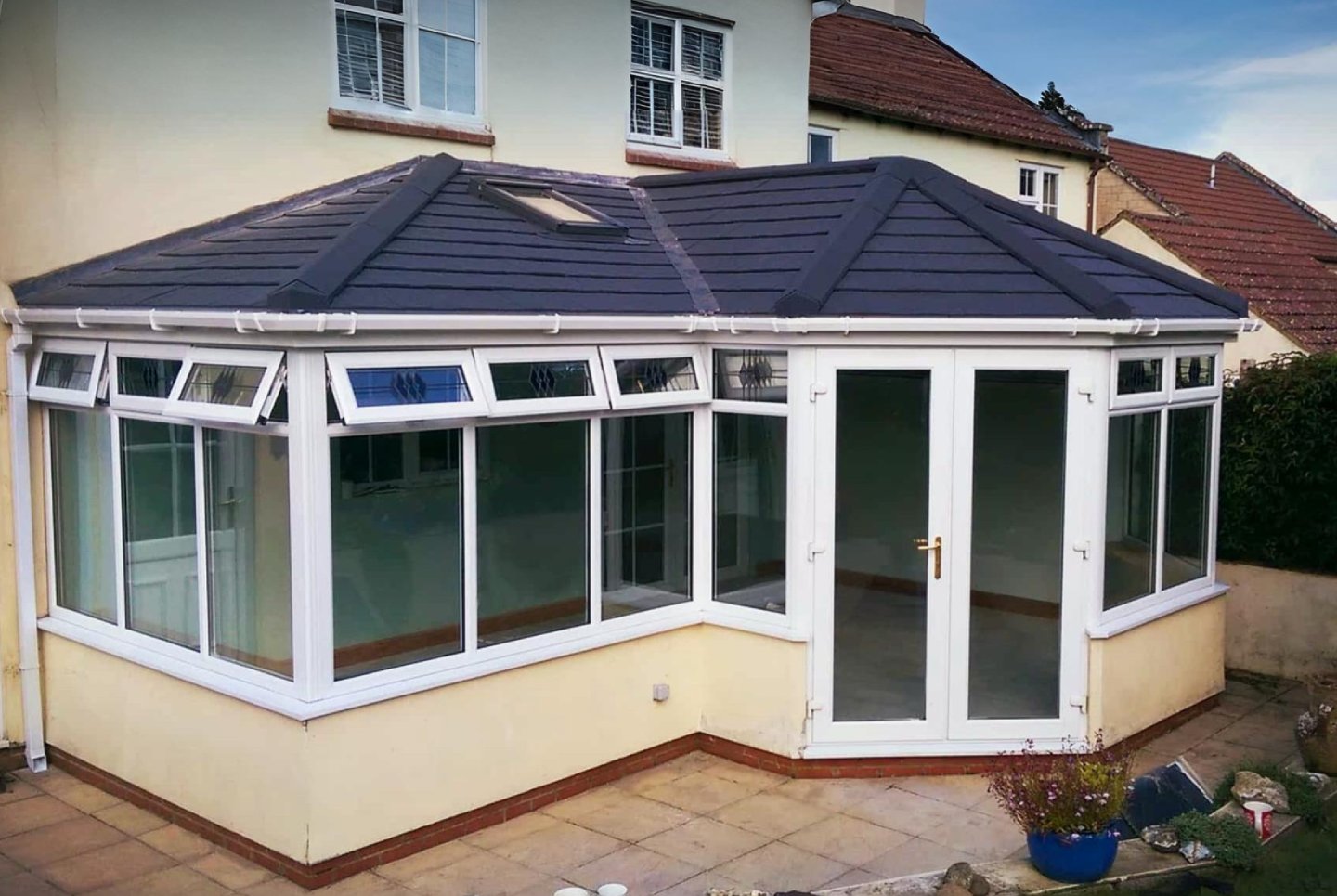 Large P-shape conservatory with grey tiled roof