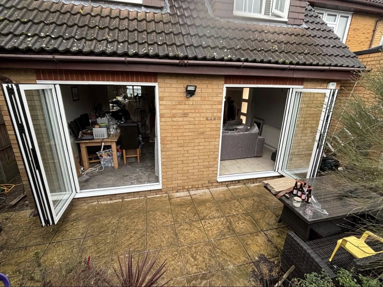 White uPVC bi-fold doors folded open onto a garden patio