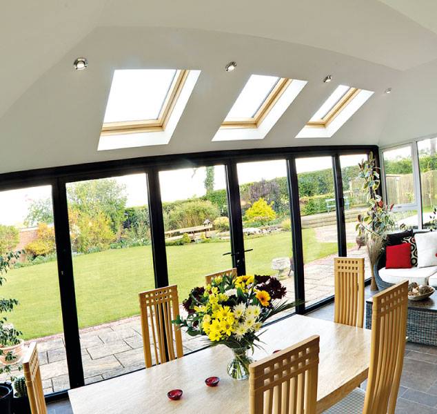 Bright orangery interior with bi-fold doors opening onto a garden